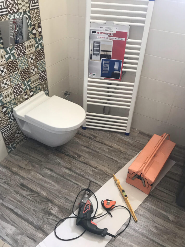 Un sèche serviette en cours de fixation